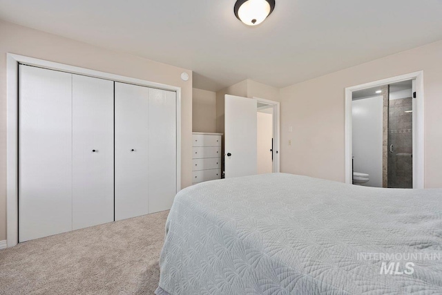 carpeted bedroom with a closet and connected bathroom