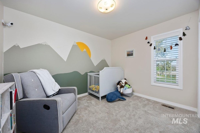 bedroom featuring a nursery area, baseboards, carpet flooring, and visible vents