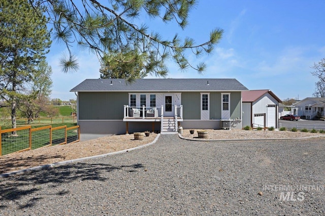 view of front of property featuring central AC, fence, and a deck