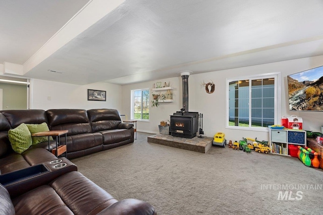 carpeted living room featuring a wood stove