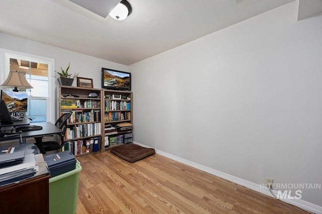 office area with light wood-style floors and baseboards