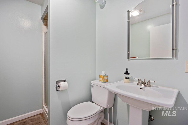 full bathroom with a shower stall and toilet