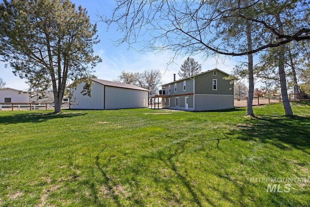 view of yard with fence and an outbuilding