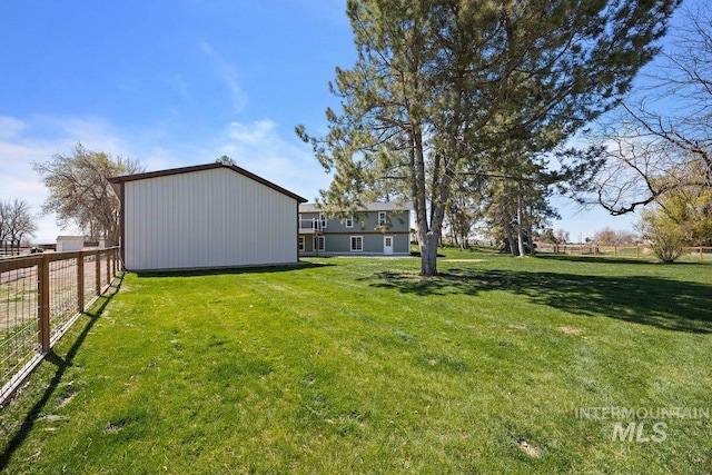 view of yard with an outbuilding and fence