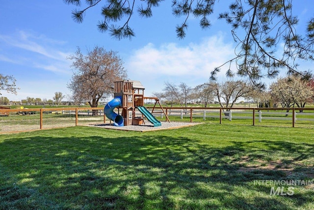 community play area featuring fence and a yard