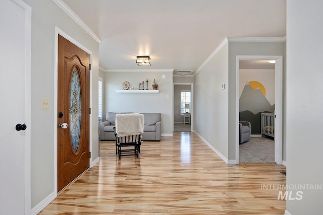 foyer entrance featuring light wood-type flooring, visible vents, baseboards, and ornamental molding