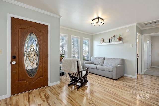 entrance foyer featuring light wood-type flooring, crown molding, and baseboards