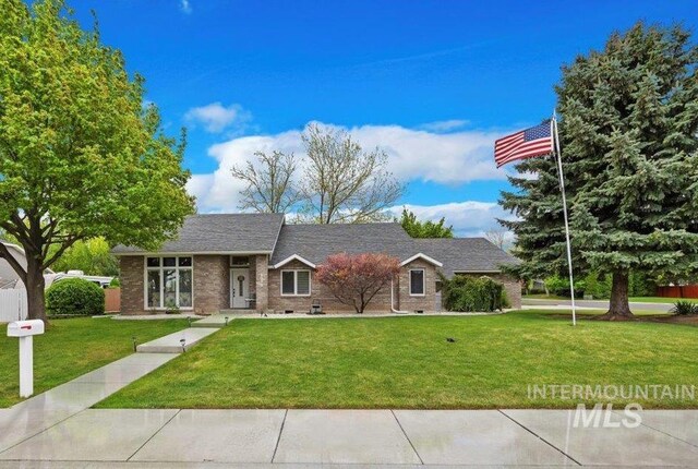 ranch-style home featuring a front lawn and brick siding