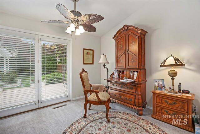 living area with light carpet, a ceiling fan, baseboards, and lofted ceiling