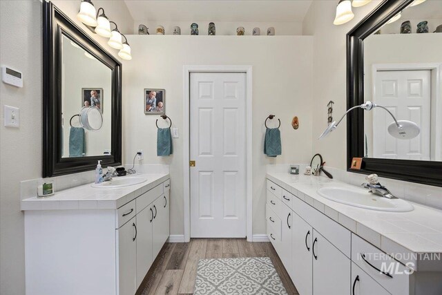 full bath featuring wood finished floors and two vanities