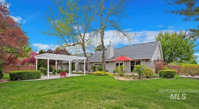 back of property with a pergola, a patio, a chimney, and a shingled roof