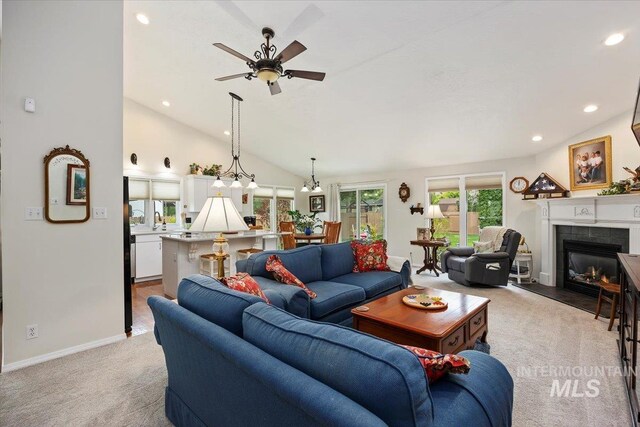 living room featuring light carpet, ceiling fan, a fireplace, lofted ceiling, and recessed lighting