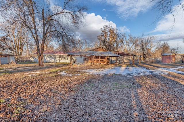 view of front of property featuring an outbuilding, gravel driveway, a carport, and a shed