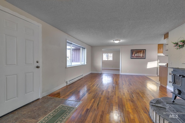 unfurnished living room featuring a baseboard radiator, wood-type flooring, a textured ceiling, and baseboards