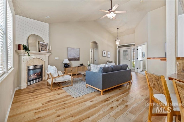 living room with ceiling fan, light hardwood / wood-style flooring, and lofted ceiling