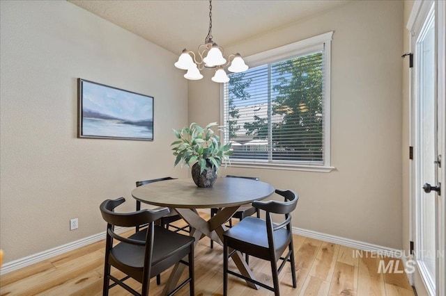 dining space with a chandelier, light hardwood / wood-style flooring, and a wealth of natural light