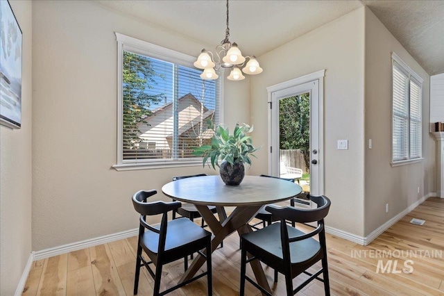 dining space with a chandelier and light hardwood / wood-style flooring