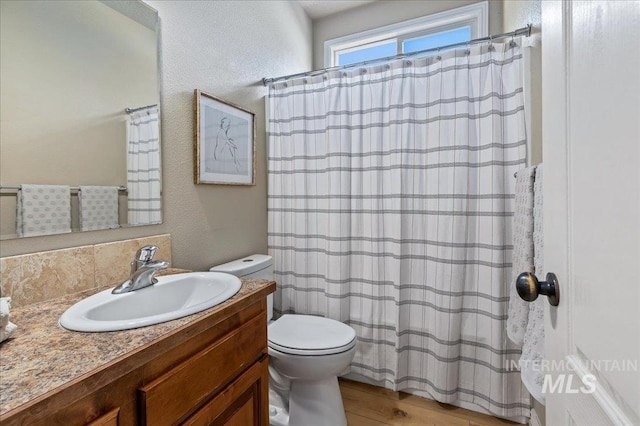 bathroom with hardwood / wood-style floors, vanity, and toilet