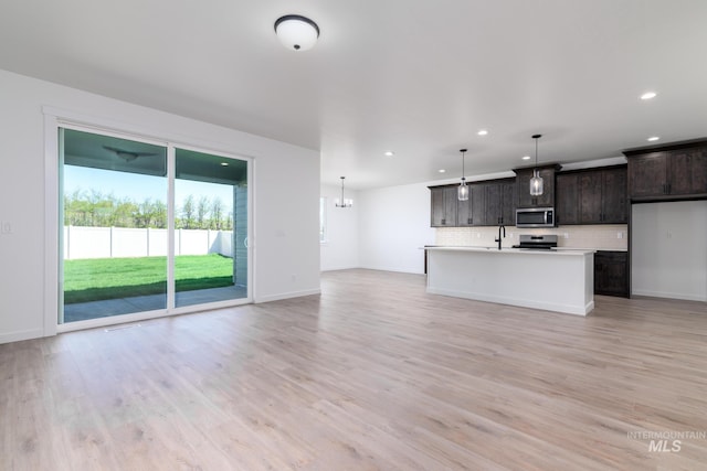 6170 W Pewter Point St, Meridian, ID 83646 - unfurnished living room with recessed lighting, light wood-style flooring, baseboards, a chandelier, and a sink