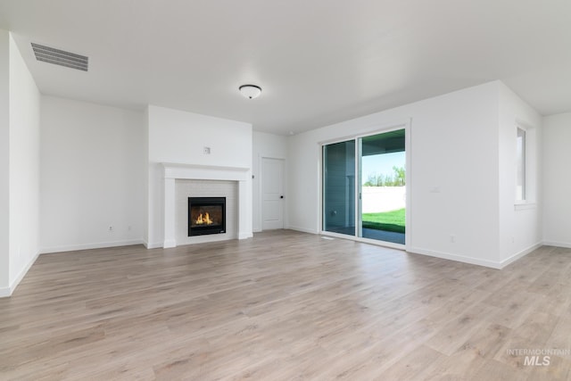 6170 W Pewter Point St, Meridian, ID 83646 - unfurnished living room featuring light wood-type flooring, a glass covered fireplace, and baseboards