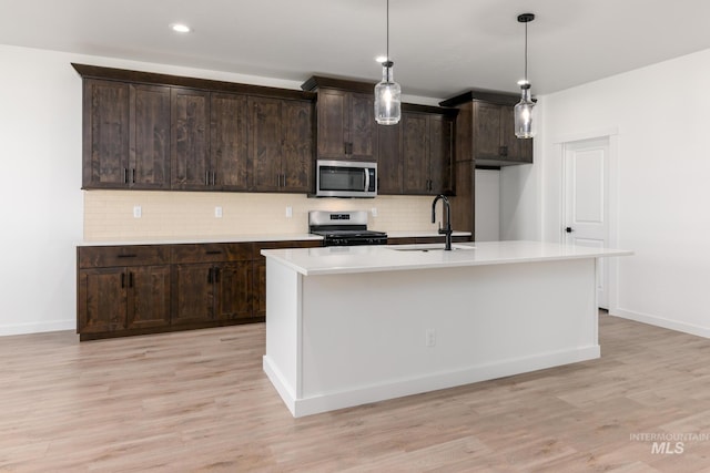 6170 W Pewter Point St, Meridian, ID 83646 - kitchen featuring stainless steel appliances, a sink, light countertops, backsplash, and light wood-style flooring
