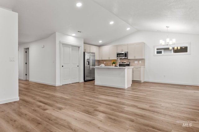 kitchen featuring open floor plan, a chandelier, vaulted ceiling, and stainless steel appliances