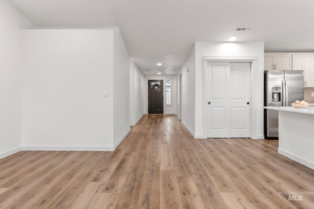 hall with light wood-style floors, baseboards, recessed lighting, and visible vents