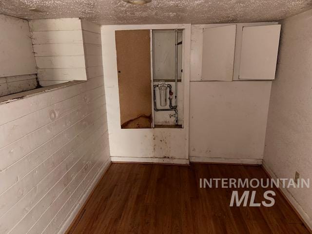 empty room with wood-type flooring and a textured ceiling