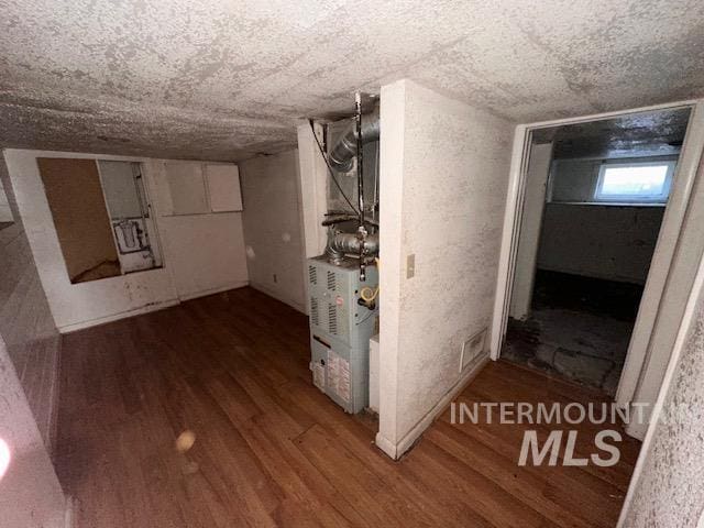 basement with a textured ceiling and hardwood / wood-style flooring