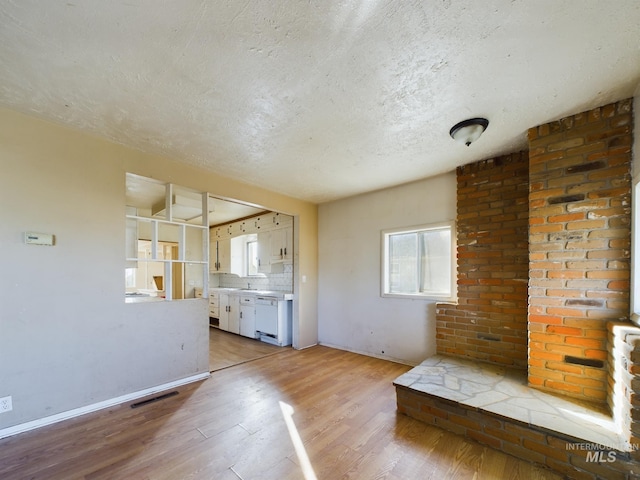 interior space with a textured ceiling and light wood-type flooring