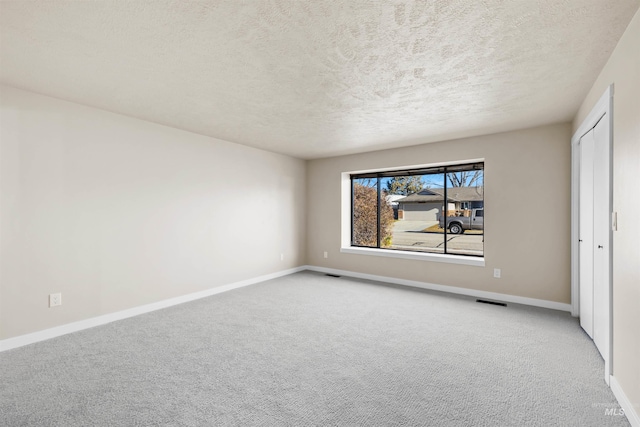 unfurnished bedroom featuring light colored carpet and a textured ceiling