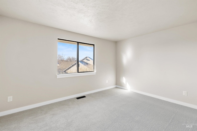 carpeted spare room featuring a textured ceiling