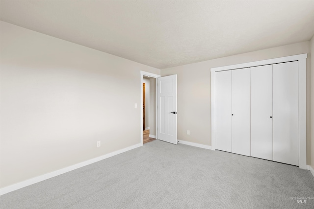 unfurnished bedroom with a closet and light colored carpet