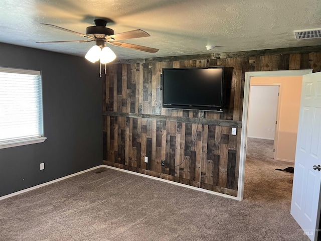2059 Spring Creek Dr, Fruitland, ID 83619 - unfurnished living room featuring wooden walls, carpet floors, a ceiling fan, and a textured ceiling