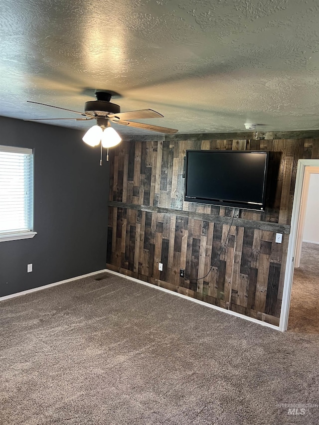2059 Spring Creek Dr, Fruitland, ID 83619 - unfurnished living room featuring wooden walls, carpet floors, a textured ceiling, and ceiling fan