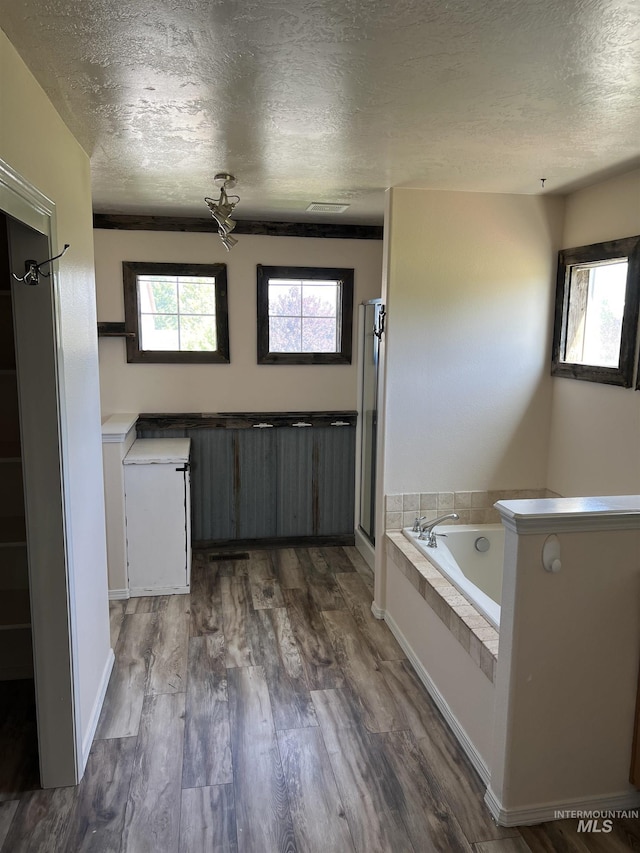 2059 Spring Creek Dr, Fruitland, ID 83619 - full bath with a textured ceiling, a garden tub, plenty of natural light, a shower stall, and wood finished floors