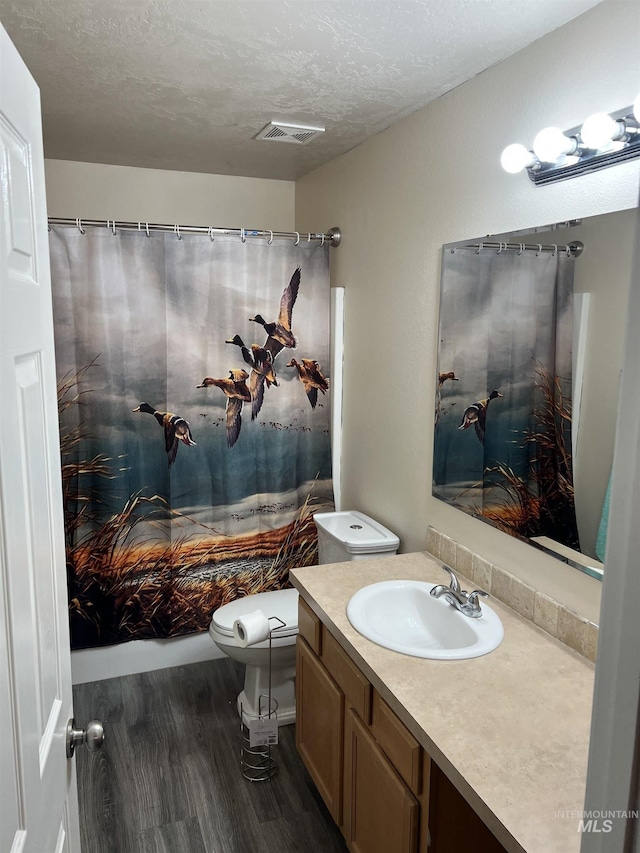 2059 Spring Creek Dr, Fruitland, ID 83619 - full bathroom featuring wood finished floors, vanity, and a textured ceiling