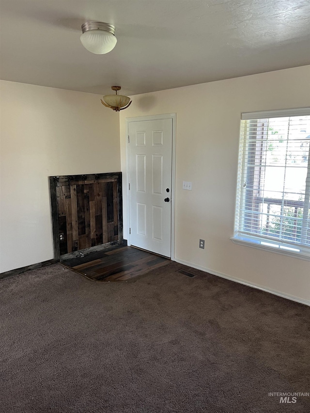 2059 Spring Creek Dr, Fruitland, ID 83619 - unfurnished living room featuring dark carpet and baseboards