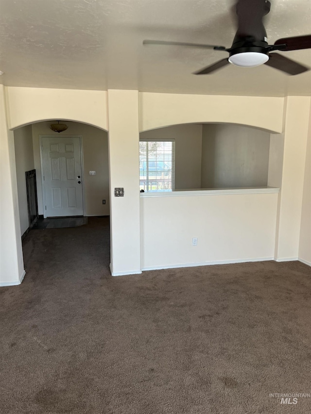 2059 Spring Creek Dr, Fruitland, ID 83619 - unfurnished room with dark carpet, arched walkways, and a ceiling fan
