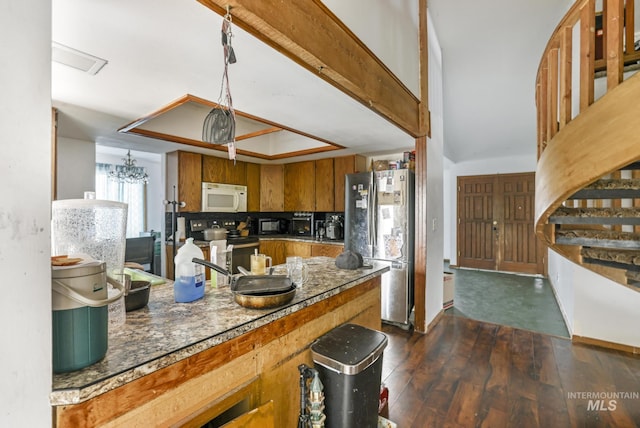 kitchen featuring dark wood-style floors, beam ceiling, brown cabinets, and stainless steel appliances