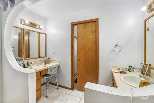 bathroom with vanity, tile patterned floors, and baseboards