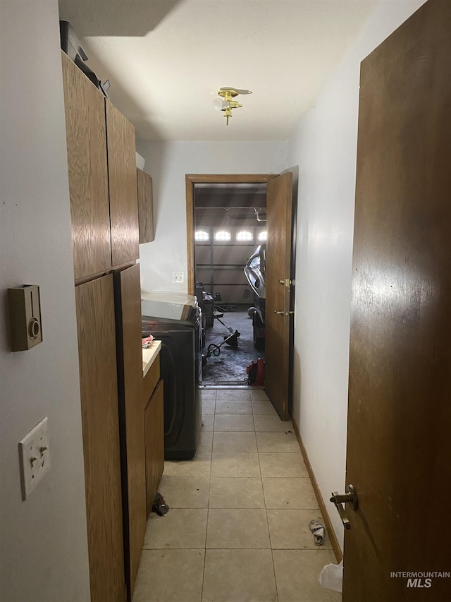 hall featuring light tile patterned floors and washer / clothes dryer