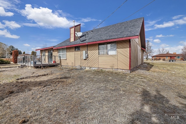 rear view of property featuring a deck and a chimney