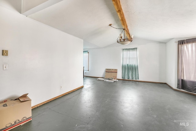 unfurnished room featuring vaulted ceiling with beams, baseboards, and concrete flooring