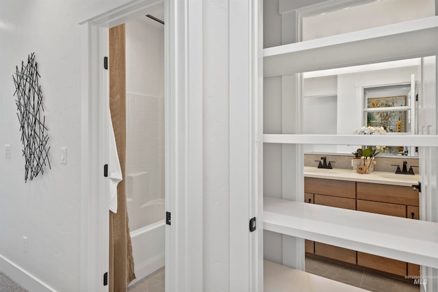 interior space with tile patterned flooring, shower / bath combo with shower curtain, and vanity