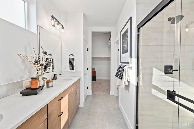 bathroom featuring a shower with door, tile patterned flooring, and vanity