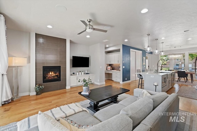 1765 E Bergeson St, Boise, ID 83706 - living room with recessed lighting, light wood-style flooring, a ceiling fan, a fireplace, and baseboards