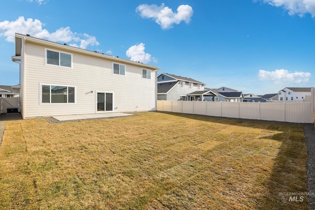 back of house with a patio area and a yard