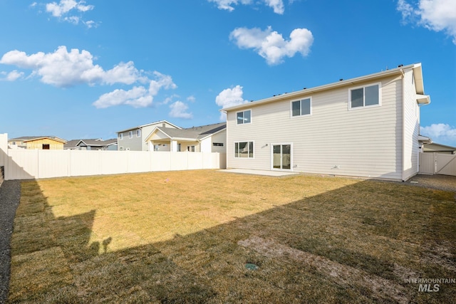 rear view of house featuring a yard and a patio