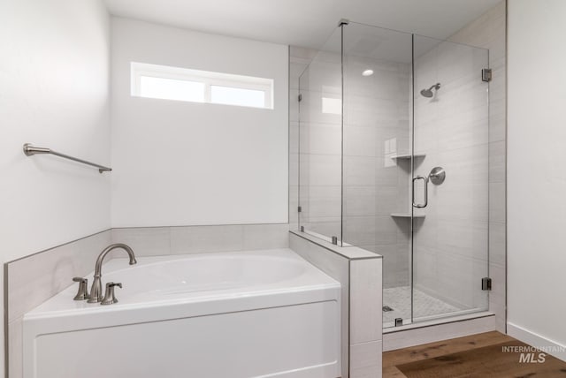 bathroom featuring hardwood / wood-style floors and plus walk in shower